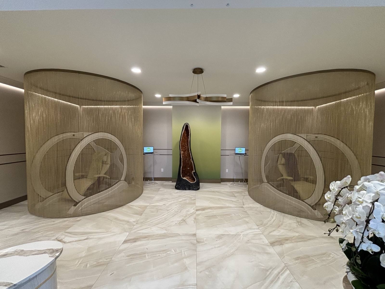 The lobby — twin gold-mesh pods and the amethyst geode, waiting.