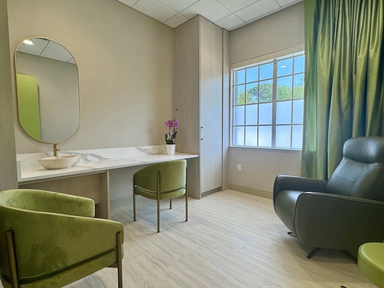 A private treatment room in stone and silk-green.